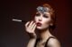 Beautiful young woman with smoky eyes and full red lips holding cigarette holder. Massive crystal hair accessory on head. Retro styling. Studio beauty shot. Copy space.