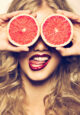 funny portrait girl holding red grapefruit infront of her face